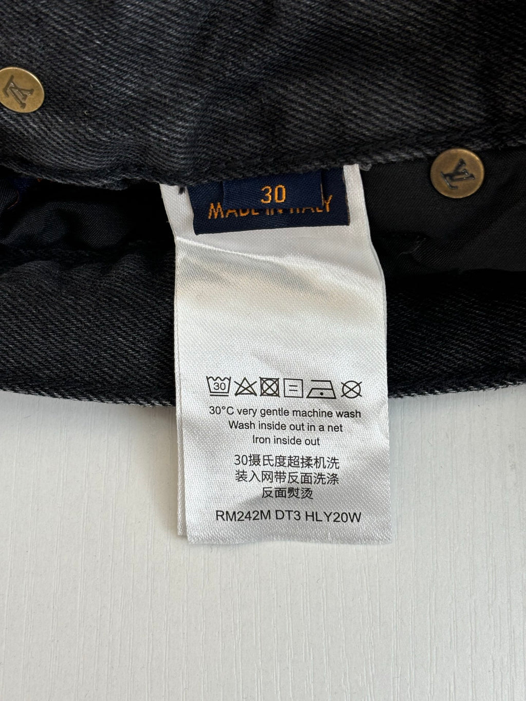 Denim pants care label with size 30 and washing symbols