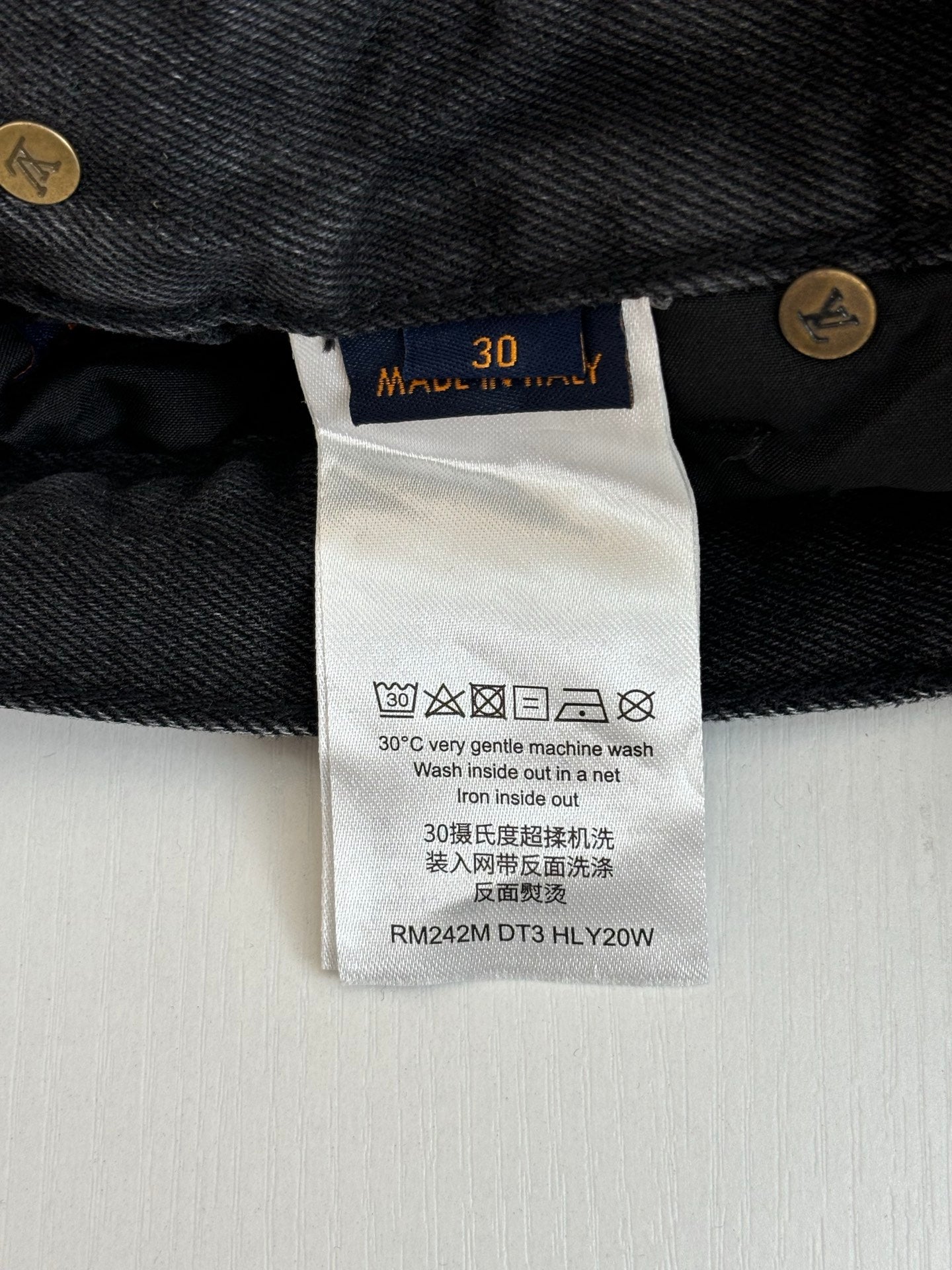 Denim pants care label with size 30 and washing symbols