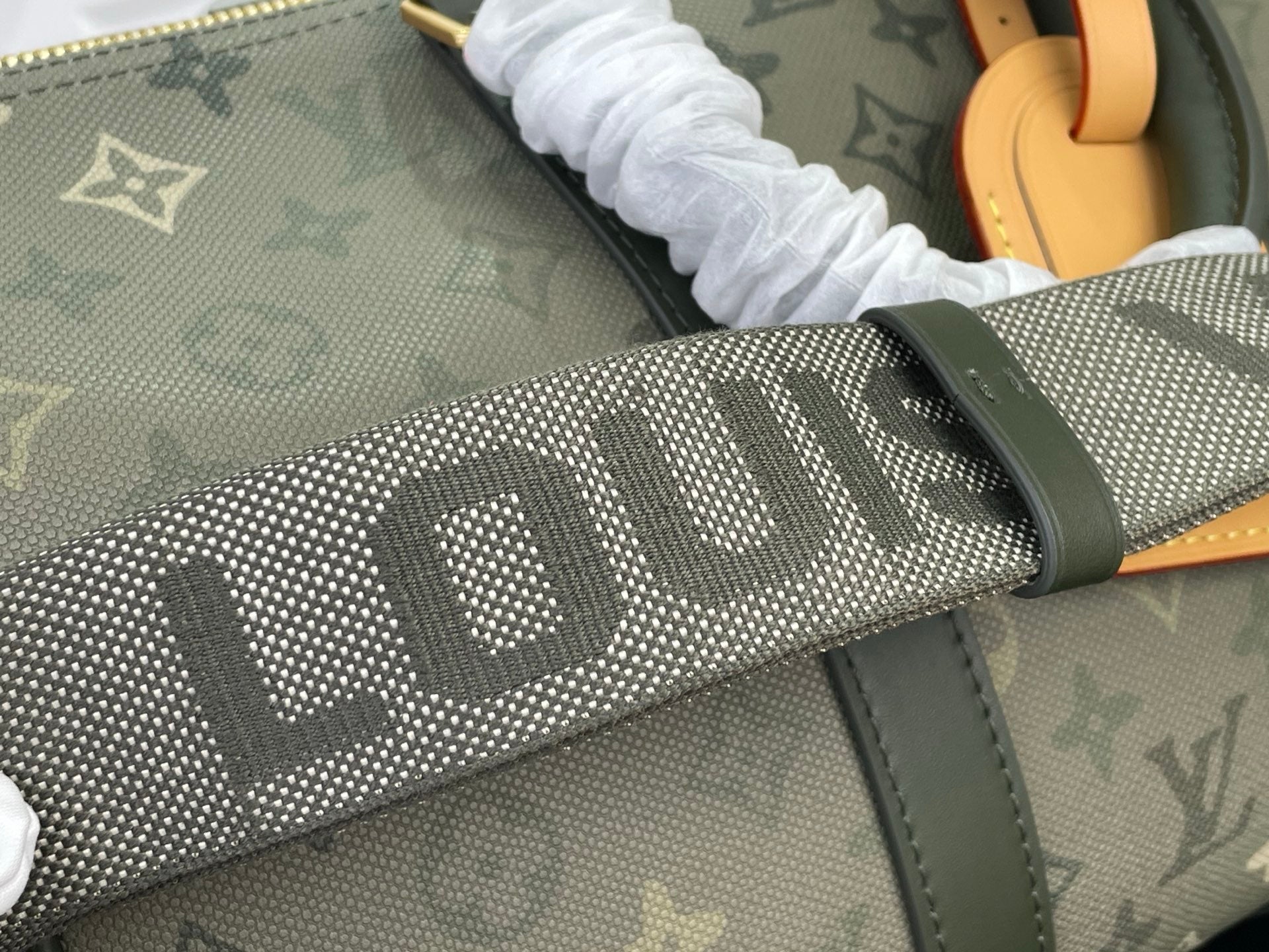 Louis Vuitton monogram fabric strap close-up with dark green trim