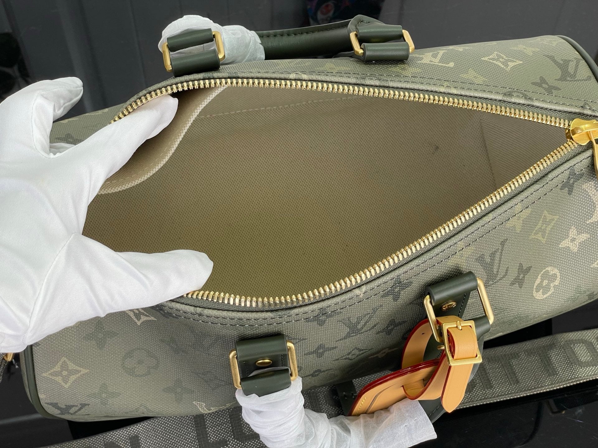 Louis Vuitton tote bag interior view with zippered pocket and gold hardware
