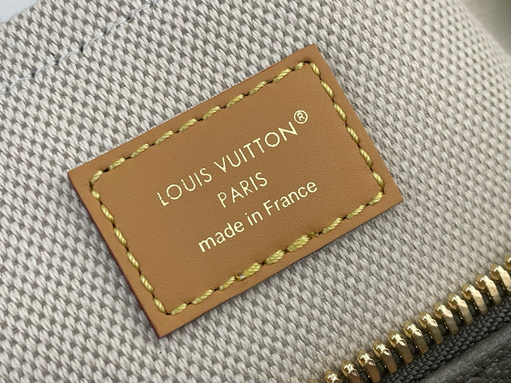 Louis Vuitton bag leather tag with stitching and made in France text, beside gold zipper