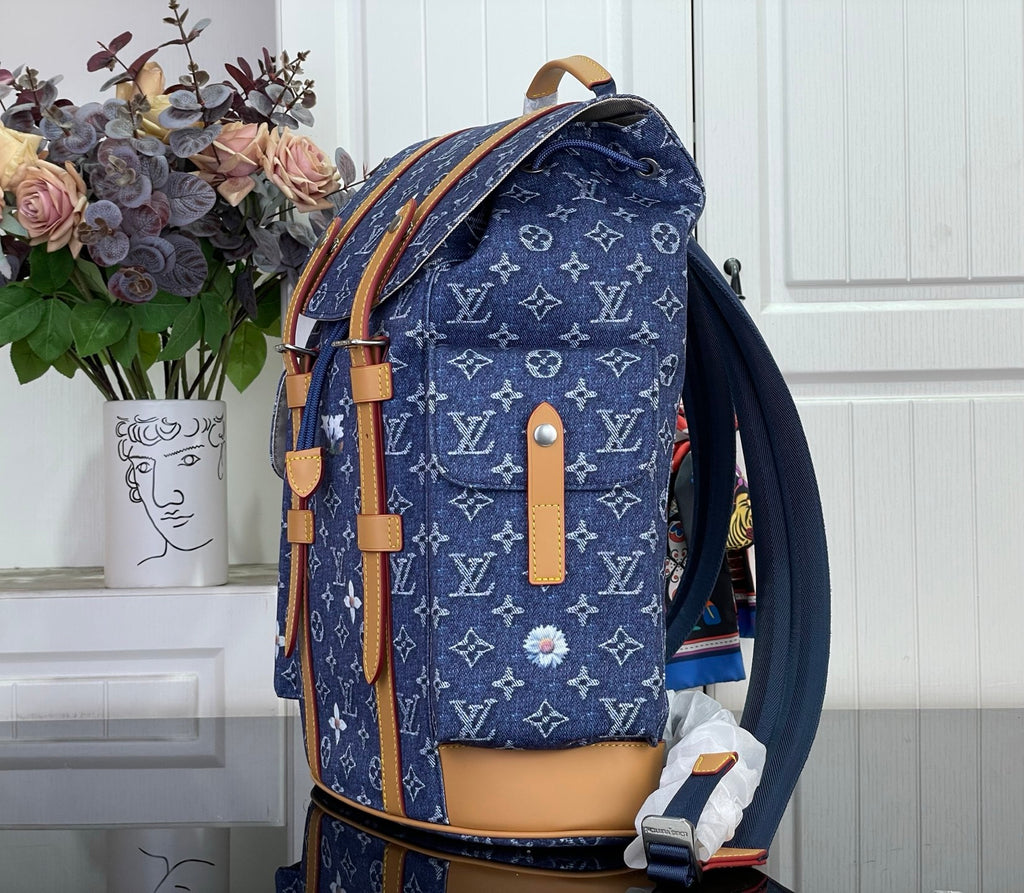 Louis Vuitton monogram canvas backpack with tan leather straps and side pocket