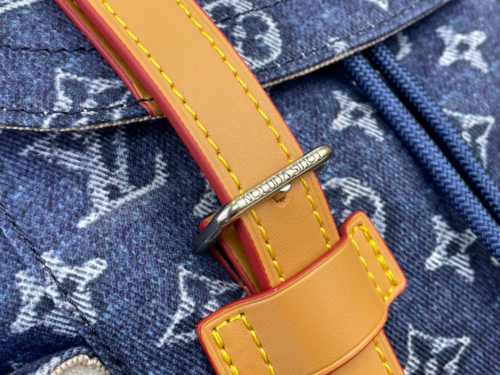 Tan leather strap with yellow stitching and metal clasp on Louis Vuitton monogram fabric