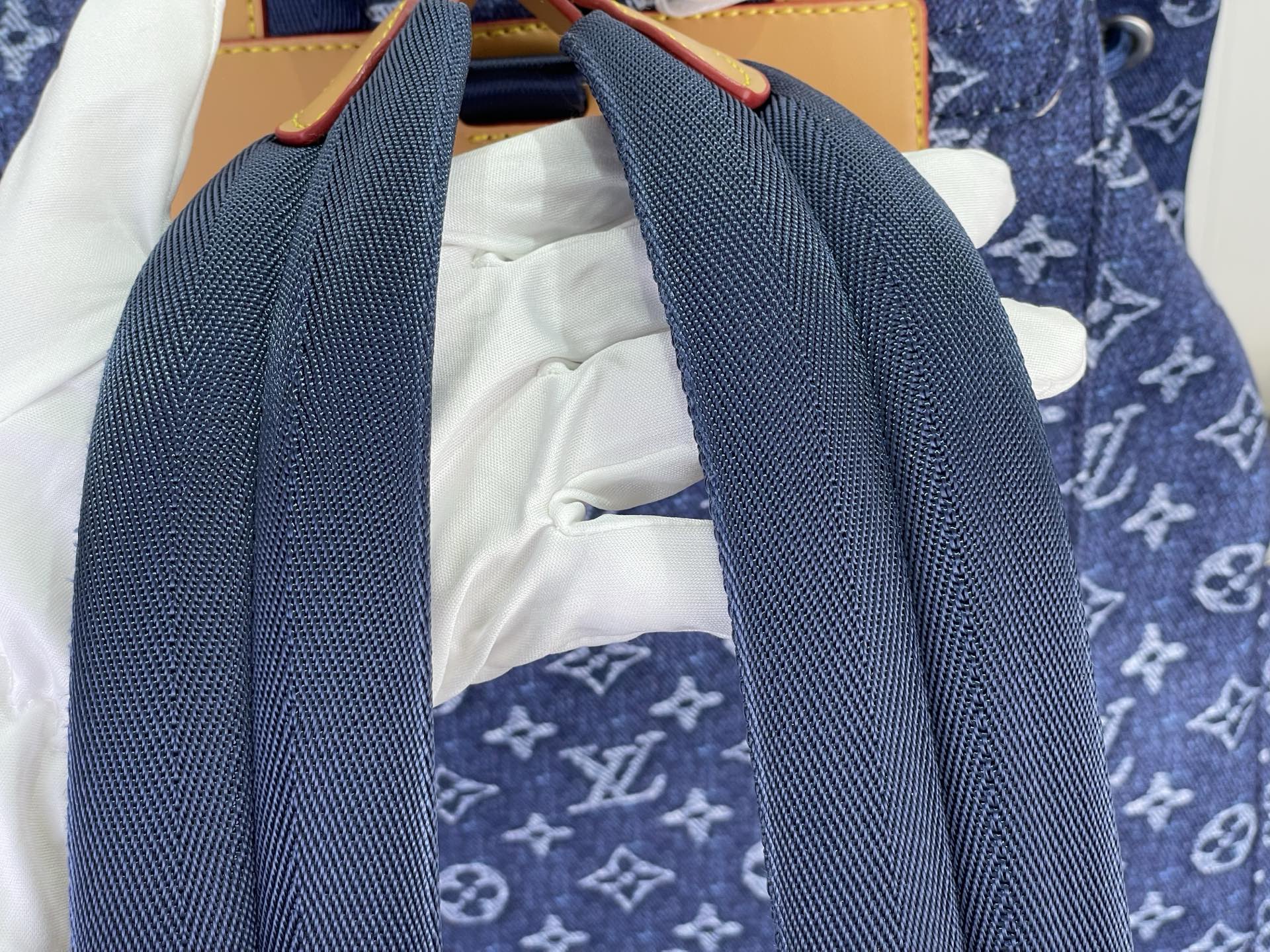 Louis Vuitton monogram backpack with dark blue shoulder straps and white interior lining