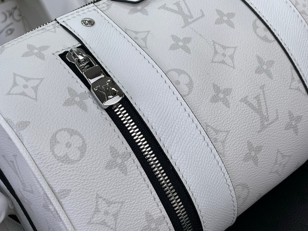 Close-up: white Louis Vuitton monogram bag strap and black zipper with silver pull