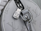 Close-up of white Louis Vuitton monogram bag hardware, D-rings, and keyring charm