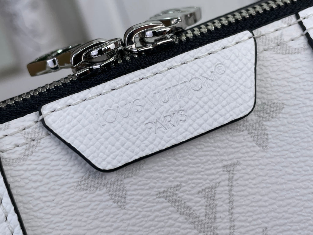 White leather bag zipper detail with embossed monogram and hardware