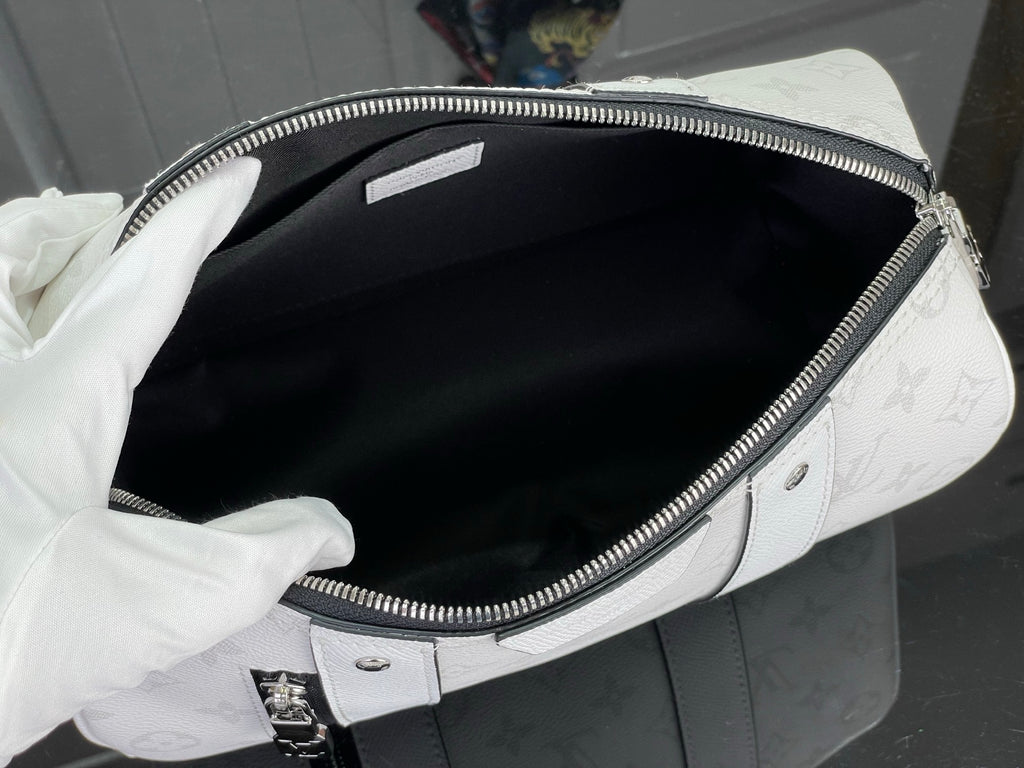 Opened white Louis Vuitton monogram duffel bag showing black interior lining