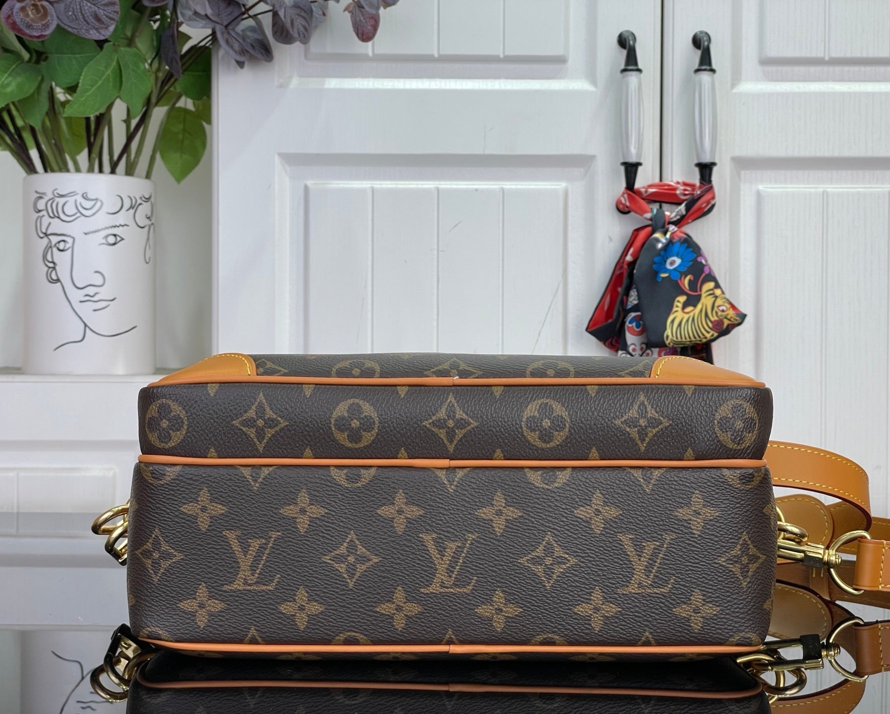 Louis Vuitton monogram bag with tan top edge and strap attachment hardware