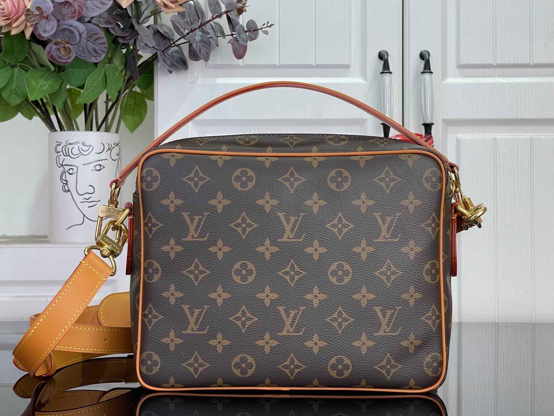 Louis Vuitton monogram handbag with tan trim and gold-tone side hardware