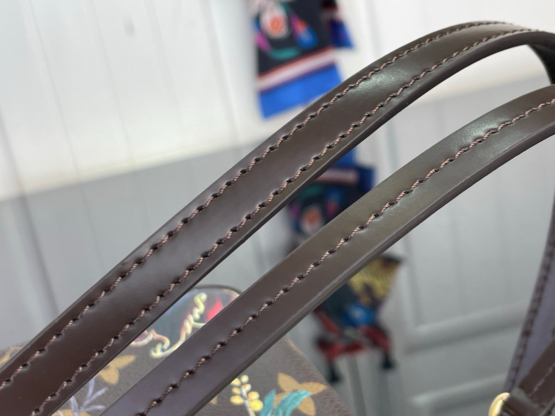 Dark leather crossbody strap with decorative edge stitching