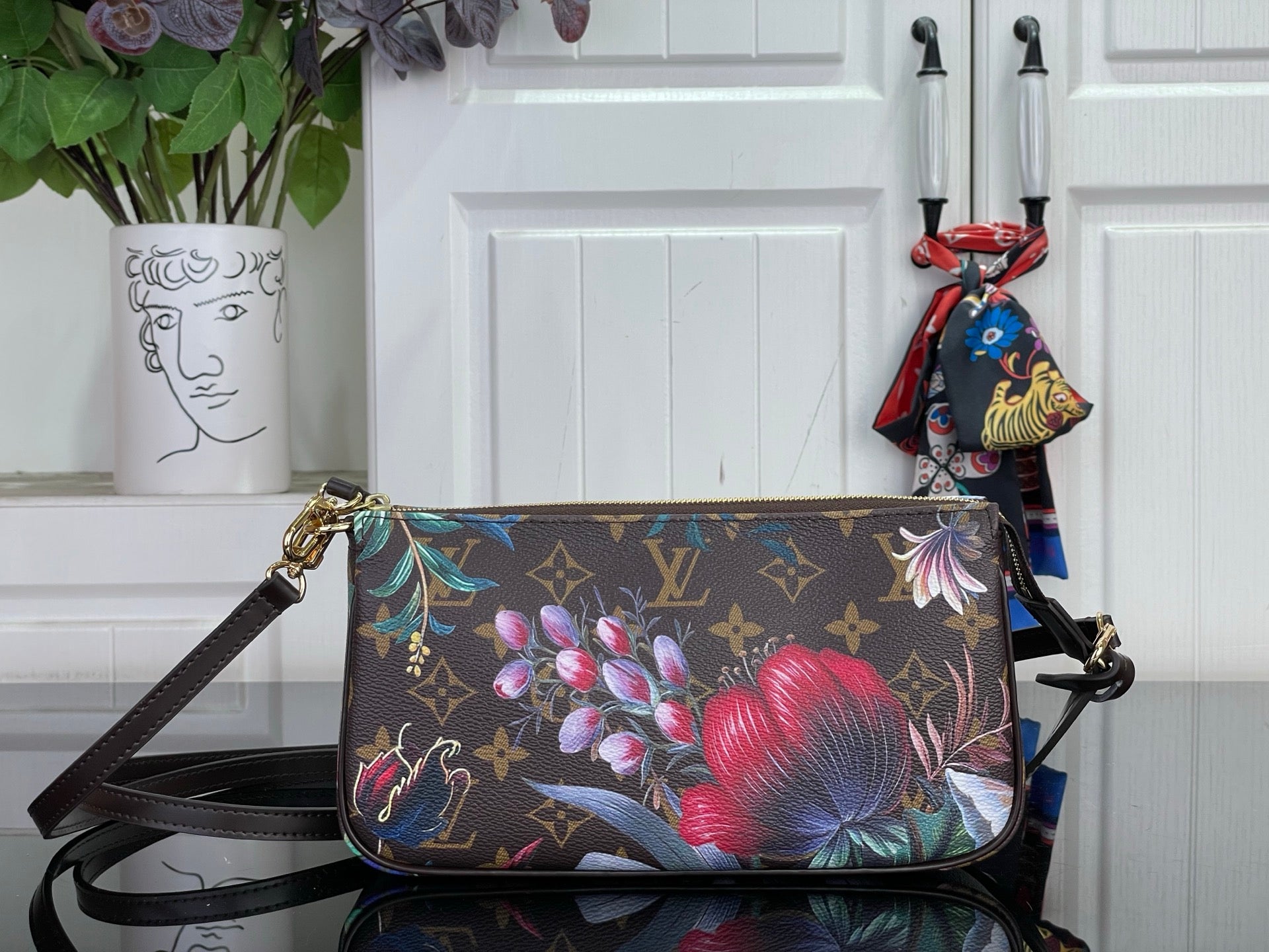 Floral monogram crossbody bag with adjustable dark leather strap