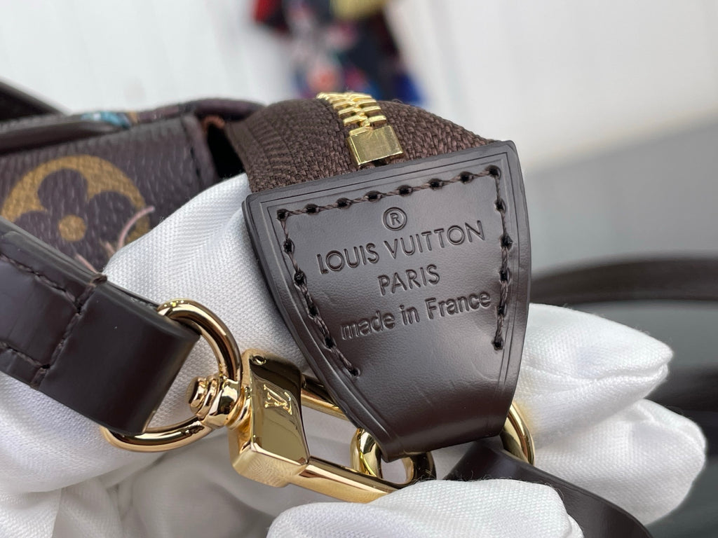 Louis Vuitton logo patch on leather strap with gold ring and clasp