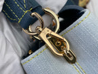 Gold-tone clasp hardware on light-blue interior lining of a two-tone satchel