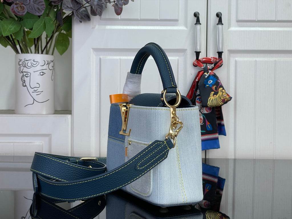 Two-tone satchel with top handle and long strap in textured blue leather with gold hardware