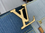Gold LV logo plaque on blue denim-look leather panel with yellow stitching detail