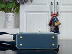 Two-tone satchel with gold corner studs and front pocket panel in blue and light blue