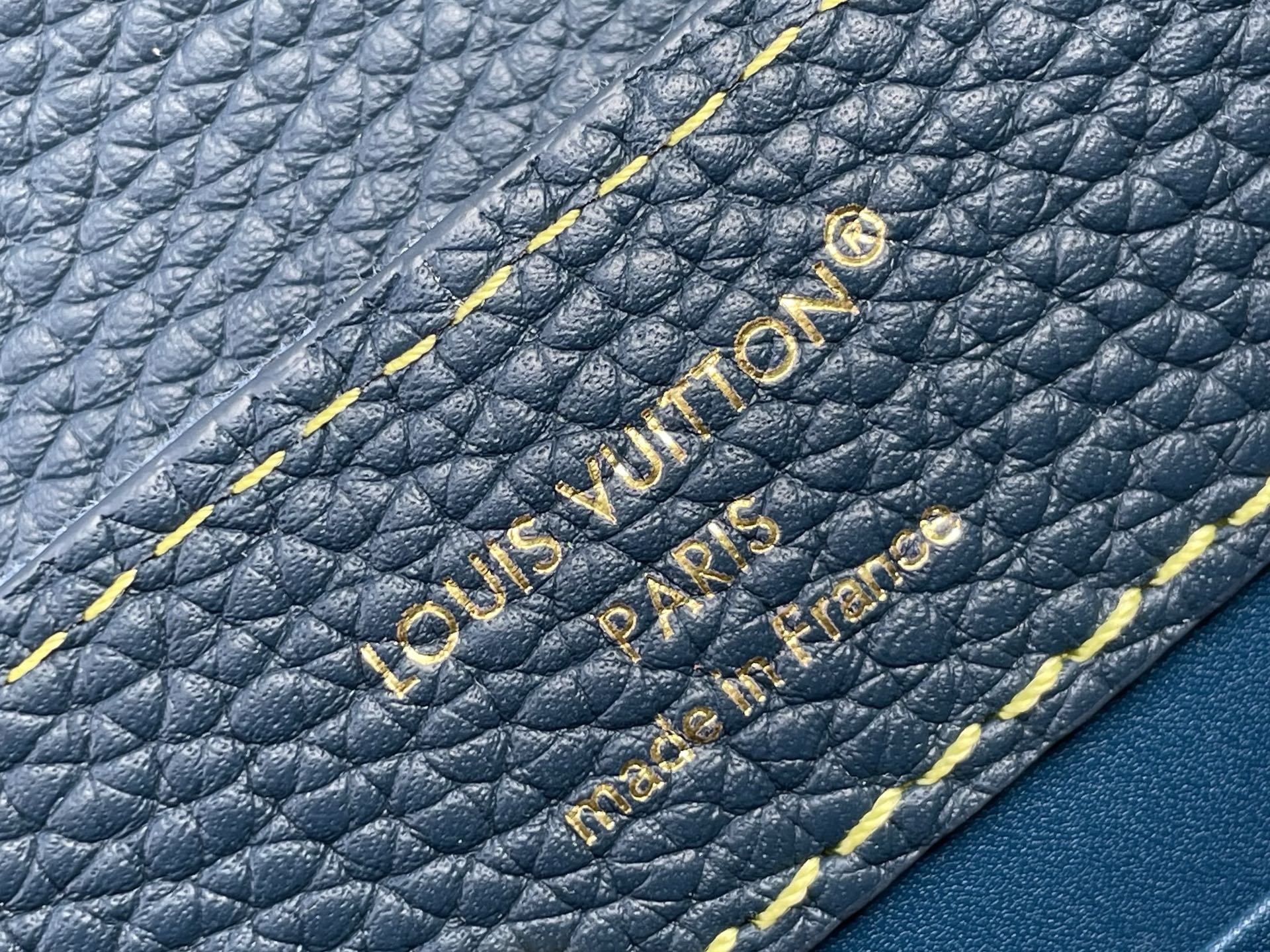 Blue pebble-grain leather with embossed Louis Vuitton Paris text and yellow edge stitching