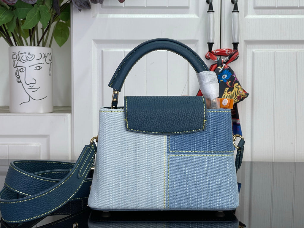 Two-tone handbag with top handle, blue front pocket, and gold-tone hardware