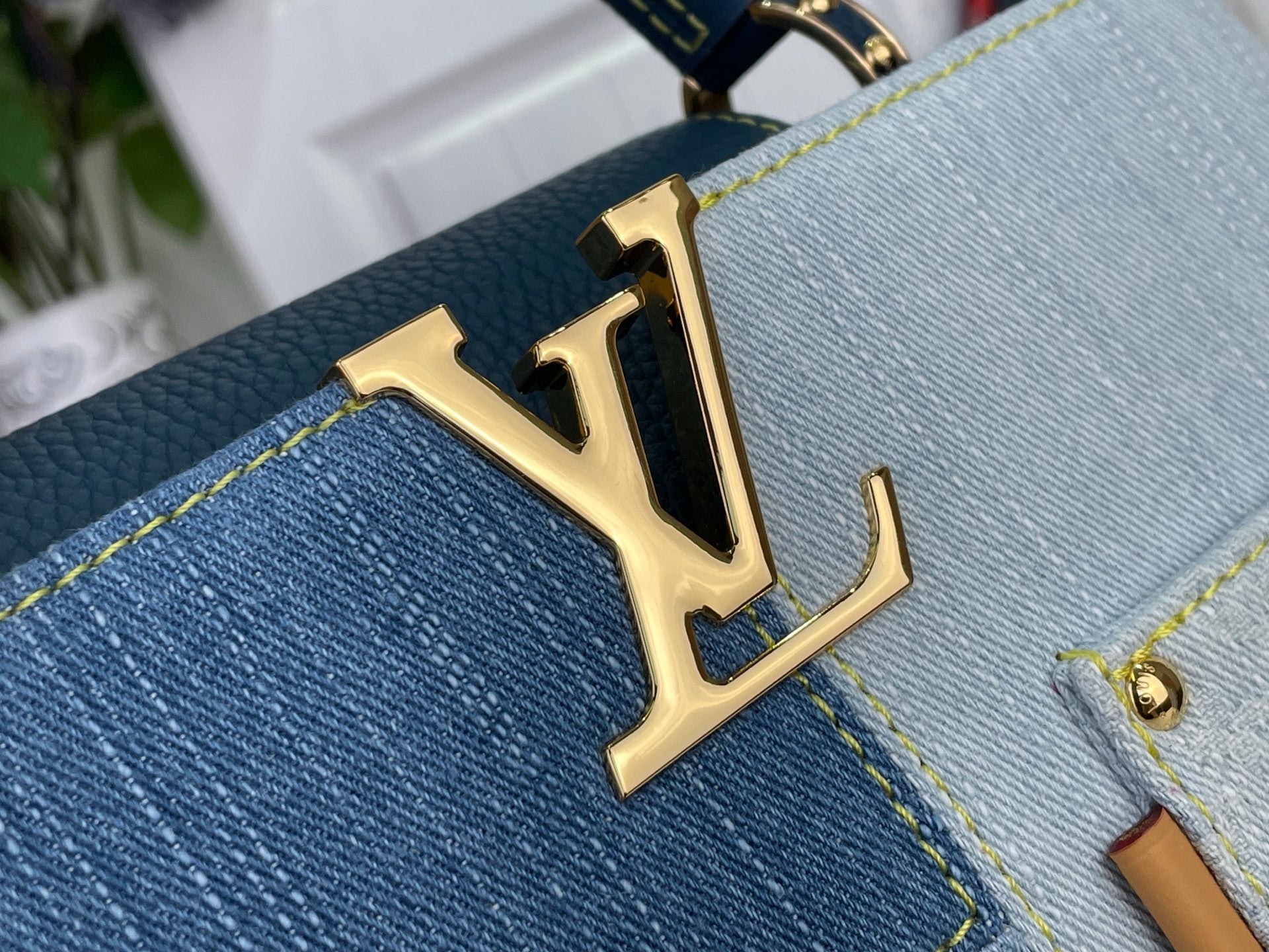 Louis Vuitton LV gold logo on blue denim-look bag front with contrast stitching
