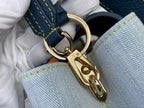 Gold chain clasp and ring hardware on blue denim-look handbag with yellow stitching