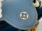 Blue pebble-grain bag corner patch with gold emblem and yellow contrast stitching