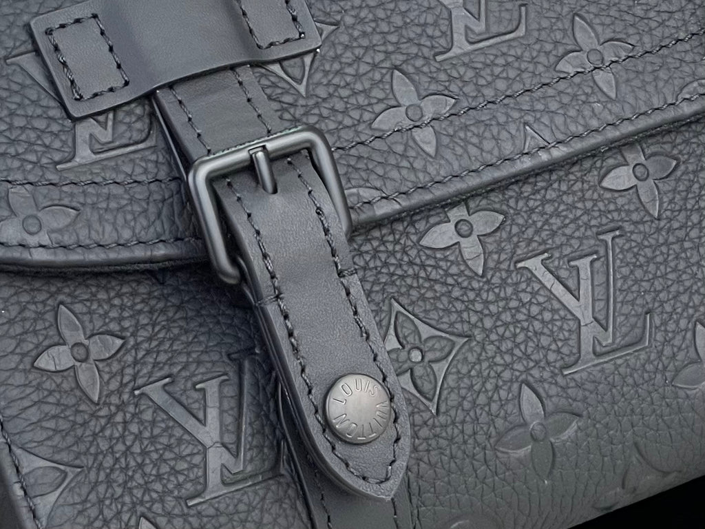 Louis Vuitton monogram bag close-up with dark hardware and embossed strap detail