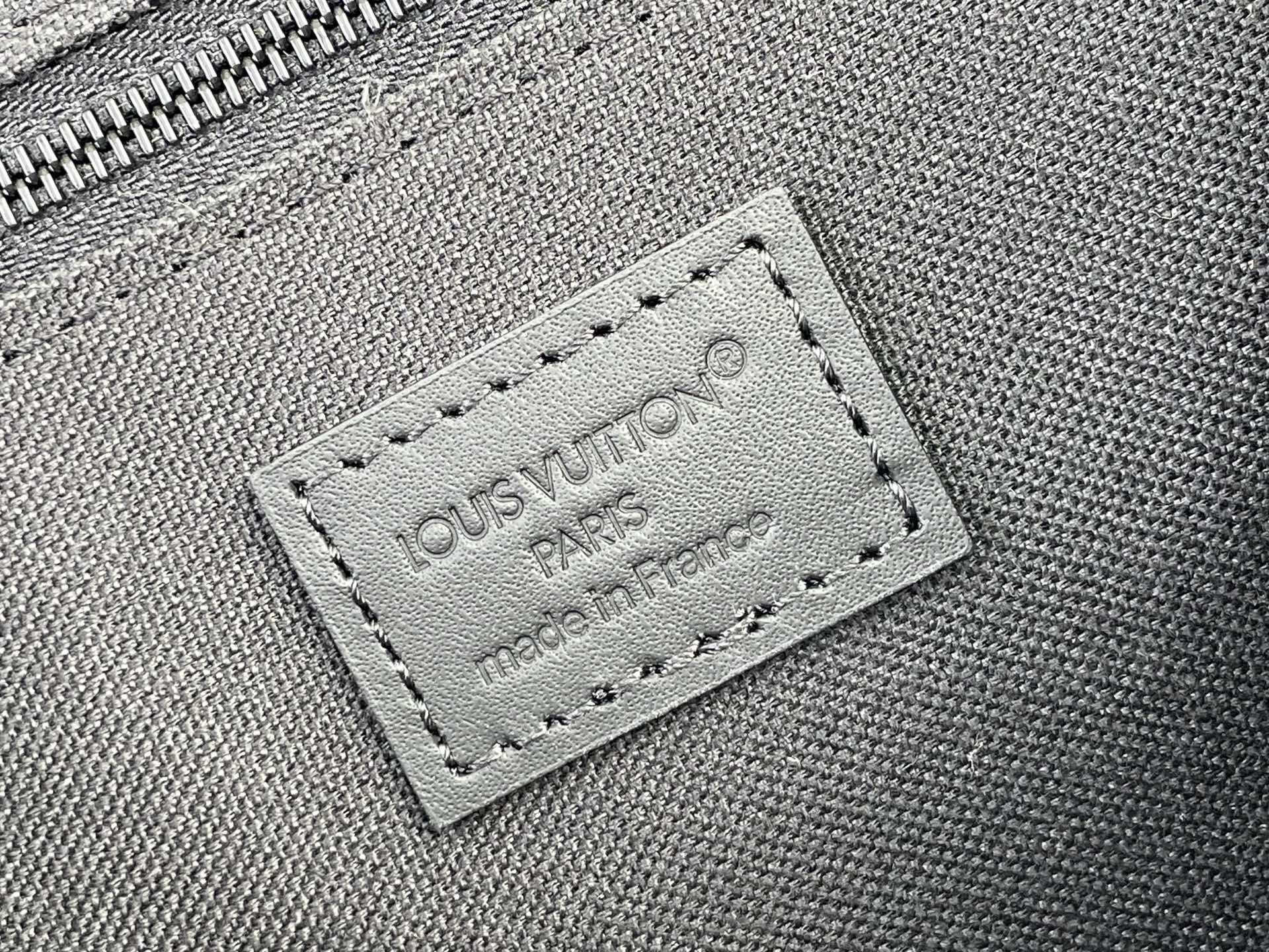Louis Vuitton bag close-up of stitched logo label reading LOUIS VUITTON PARIS, made in France