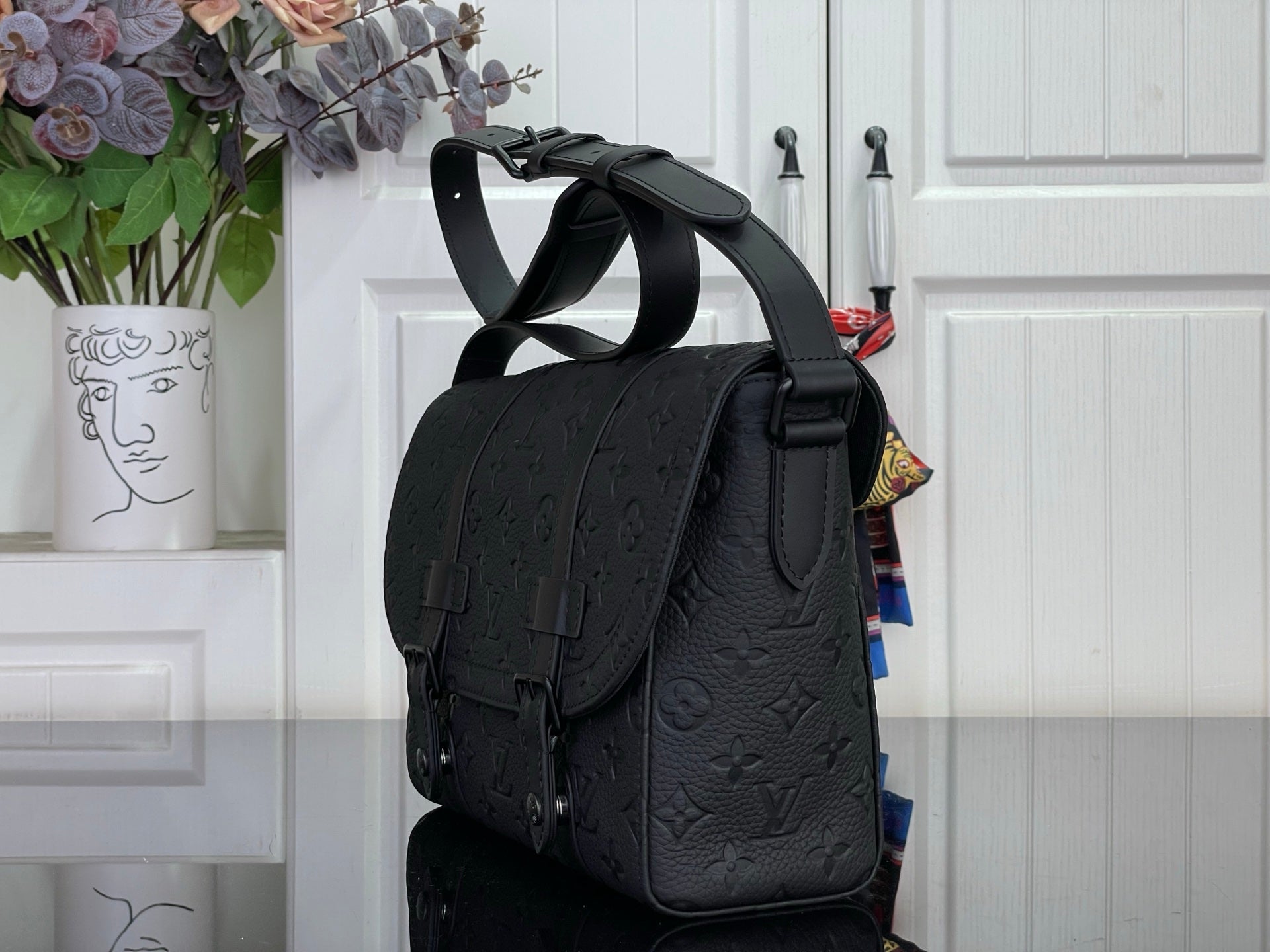 Louis Vuitton crossbody bag in dark navy with flap pocket and adjustable strap