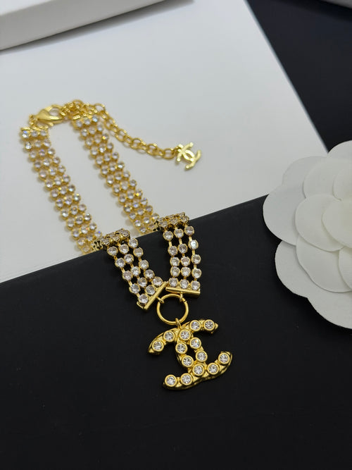 Gold-tone rhinestone multi-strand necklace with CC charm and heart pendant