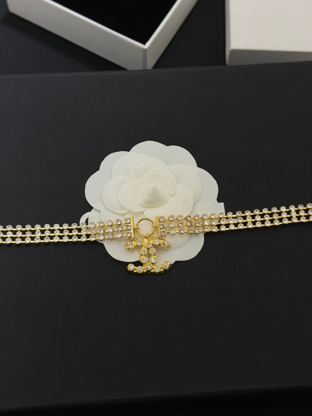Gold-tone rhinestone belt-style necklace with CC charm and dangling pendant
