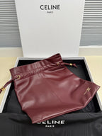 Burgundy leather drawstring pouch with strap and small logo accent