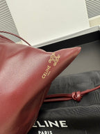 Burgundy leather bag corner with embossed Celine lettering and tied cord