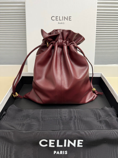 Burgundy leather drawstring bag with ruched top and cord handles