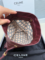 Open burgundy leather drawstring bag showing patterned fabric lining