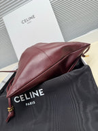 Burgundy leather drawstring bag side profile with cord strap and gold hardware