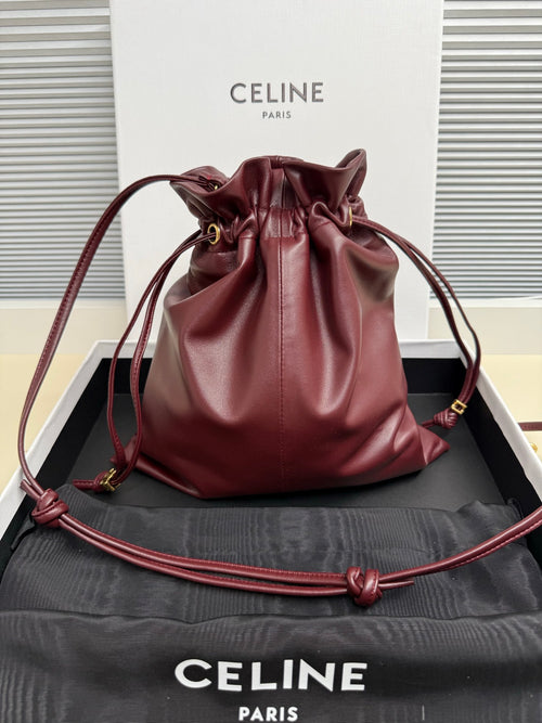 Burgundy leather drawstring bag with gathered top and gold-tone hardware