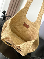 Woven straw tote bag front view with brown leather logo patch