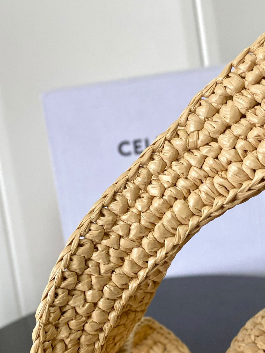 Woven straw tote bag corner view with tight interlaced weave