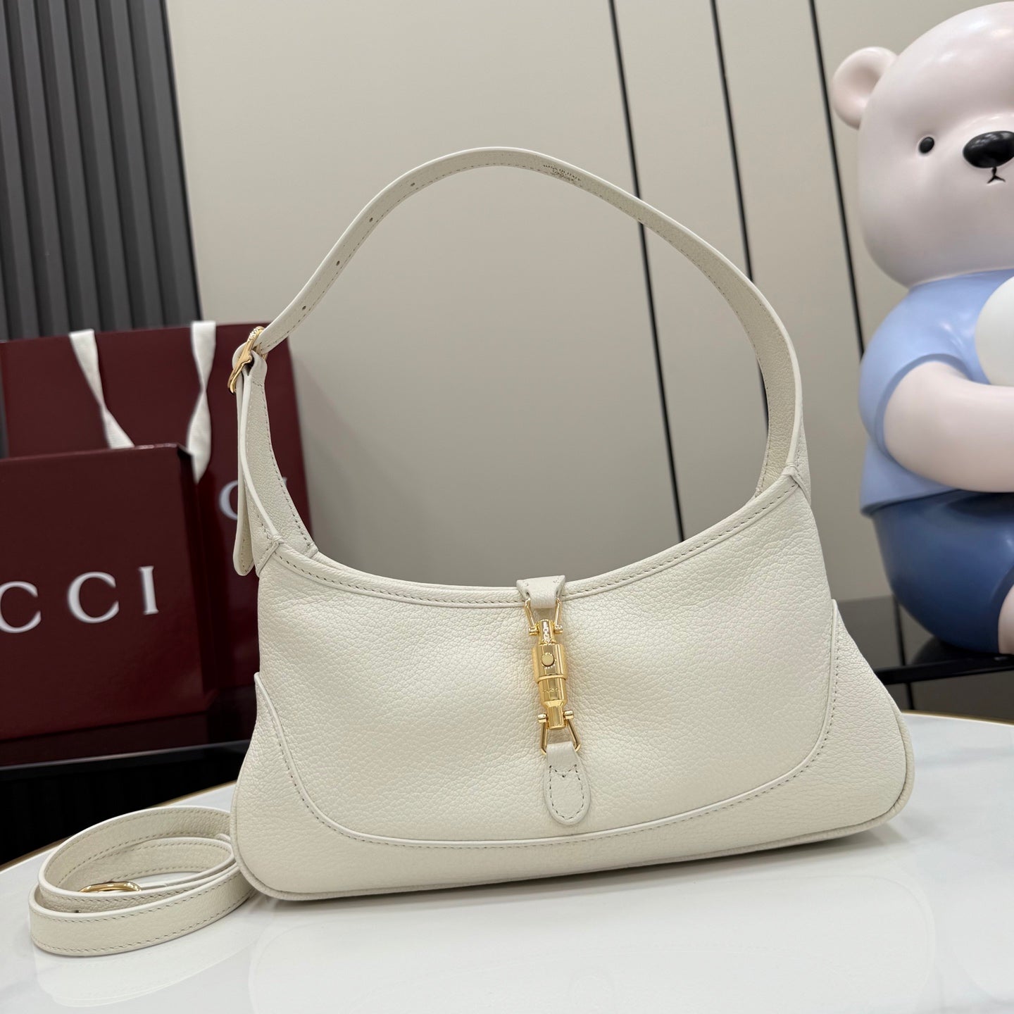 Gucci white leather hobo bag with gold-tone zipper pull and top handle