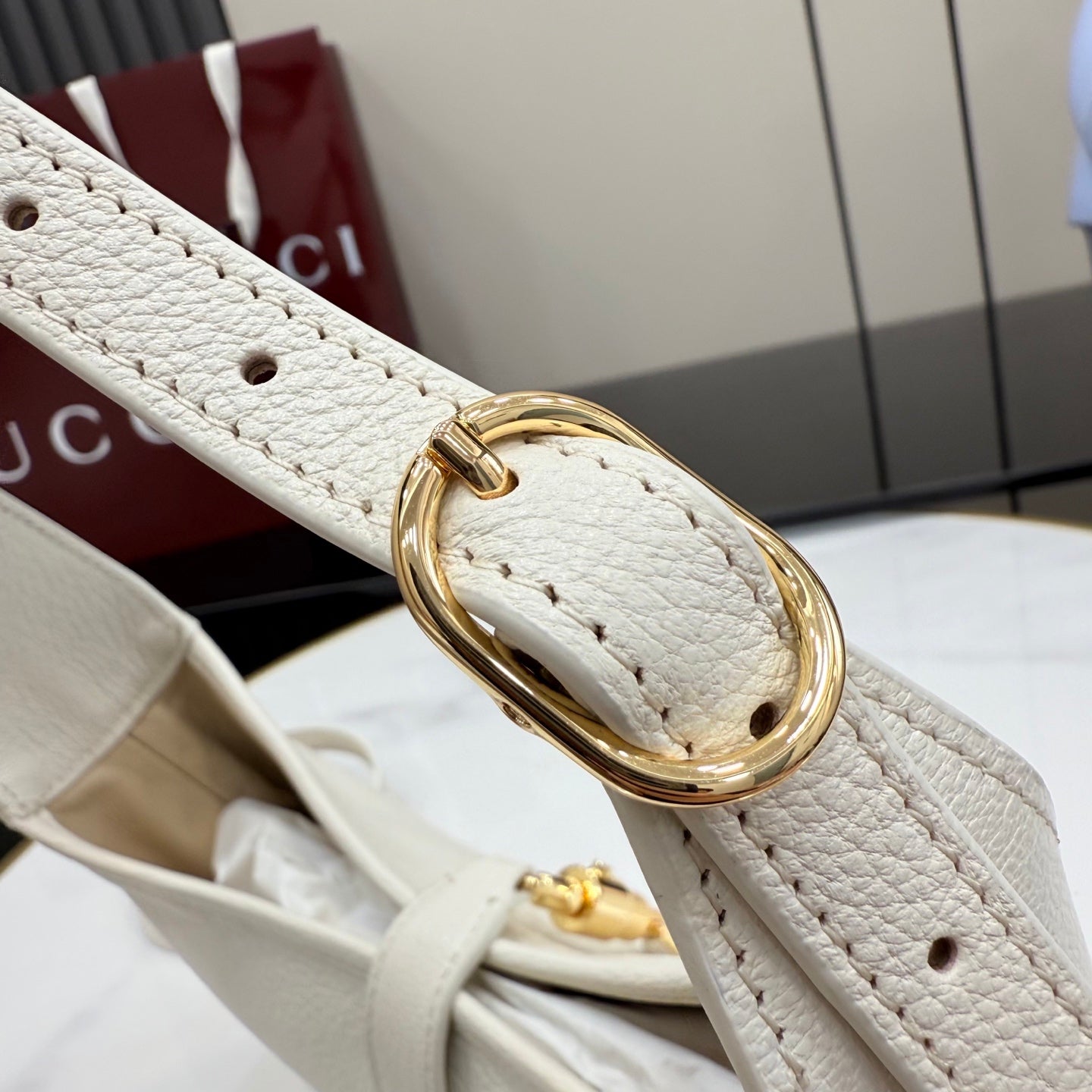Gucci white leather strap with gold-tone oval buckle ring and stitch detail
