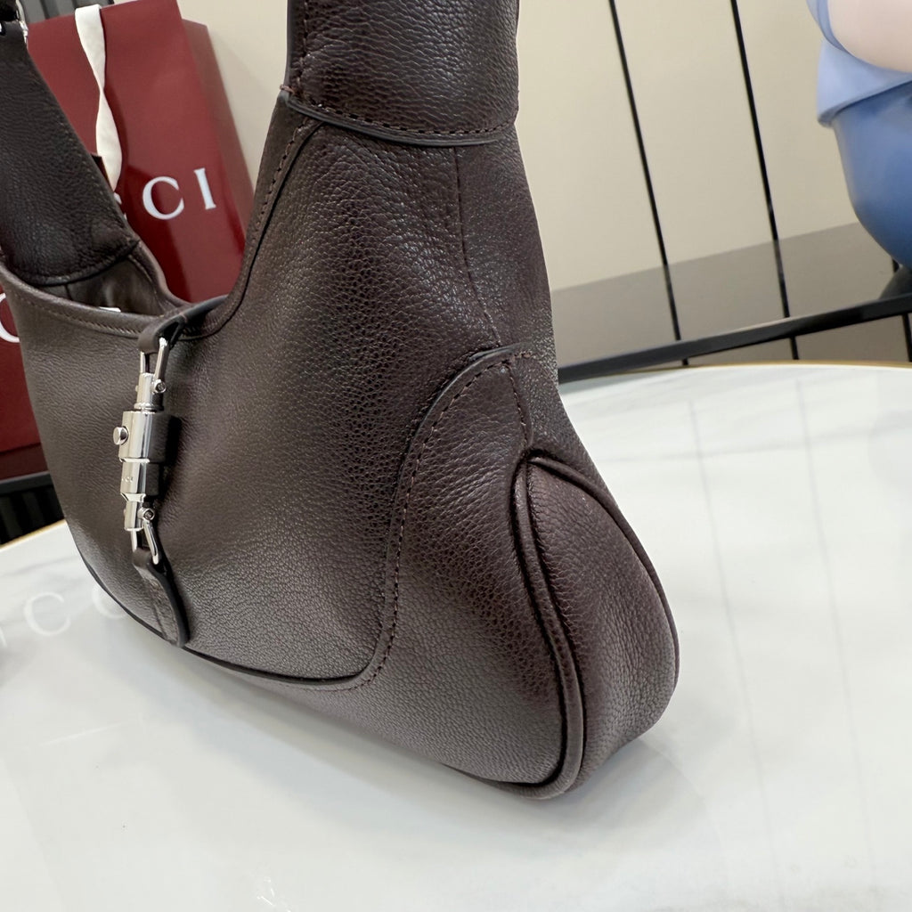 Gucci leather shoulder bag with adjustable strap and silver-toned hardware, dark