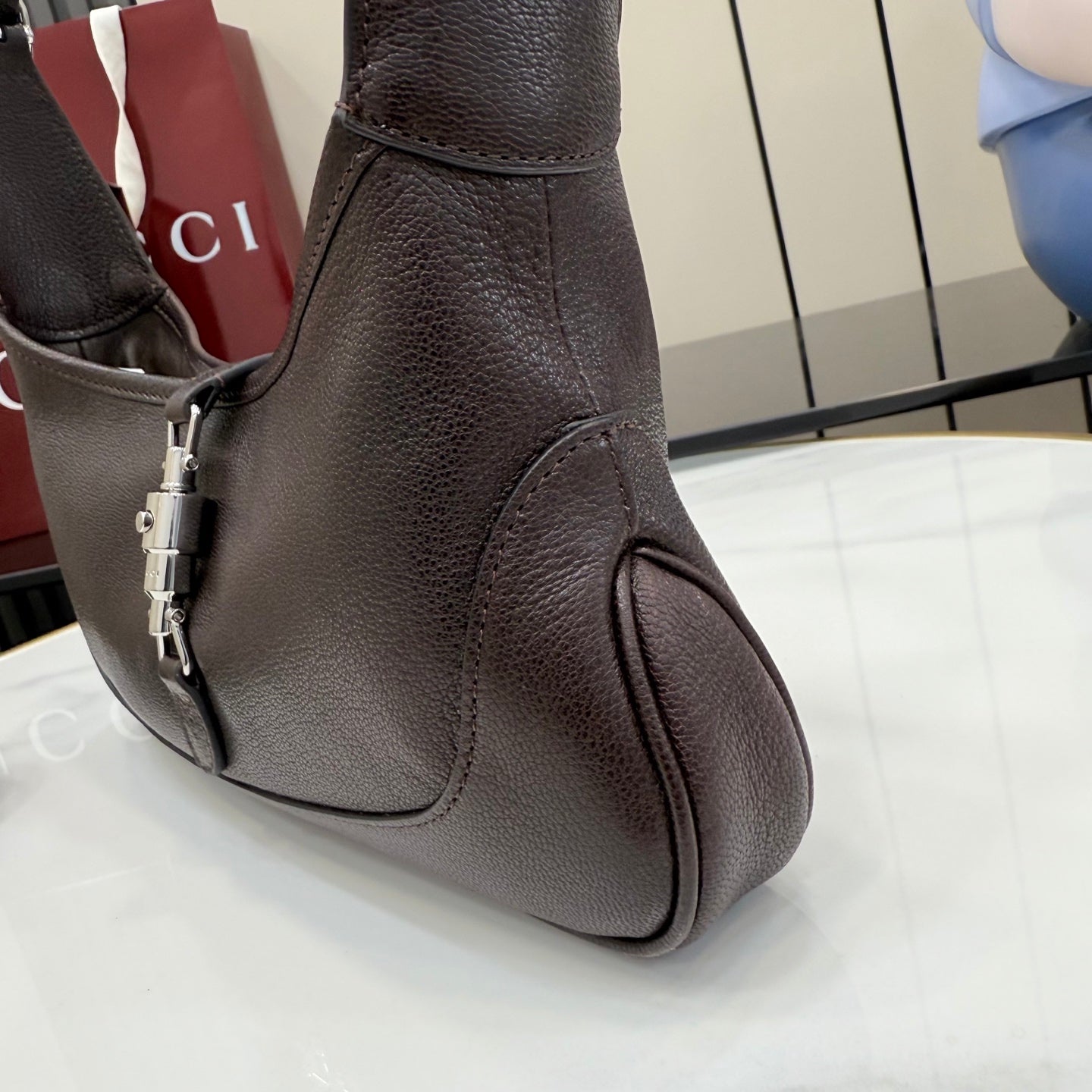 Gucci leather shoulder bag with adjustable strap and silver-toned hardware, dark