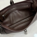 Dark leather hobo bag interior with zippered pocket and metal snap tab at base