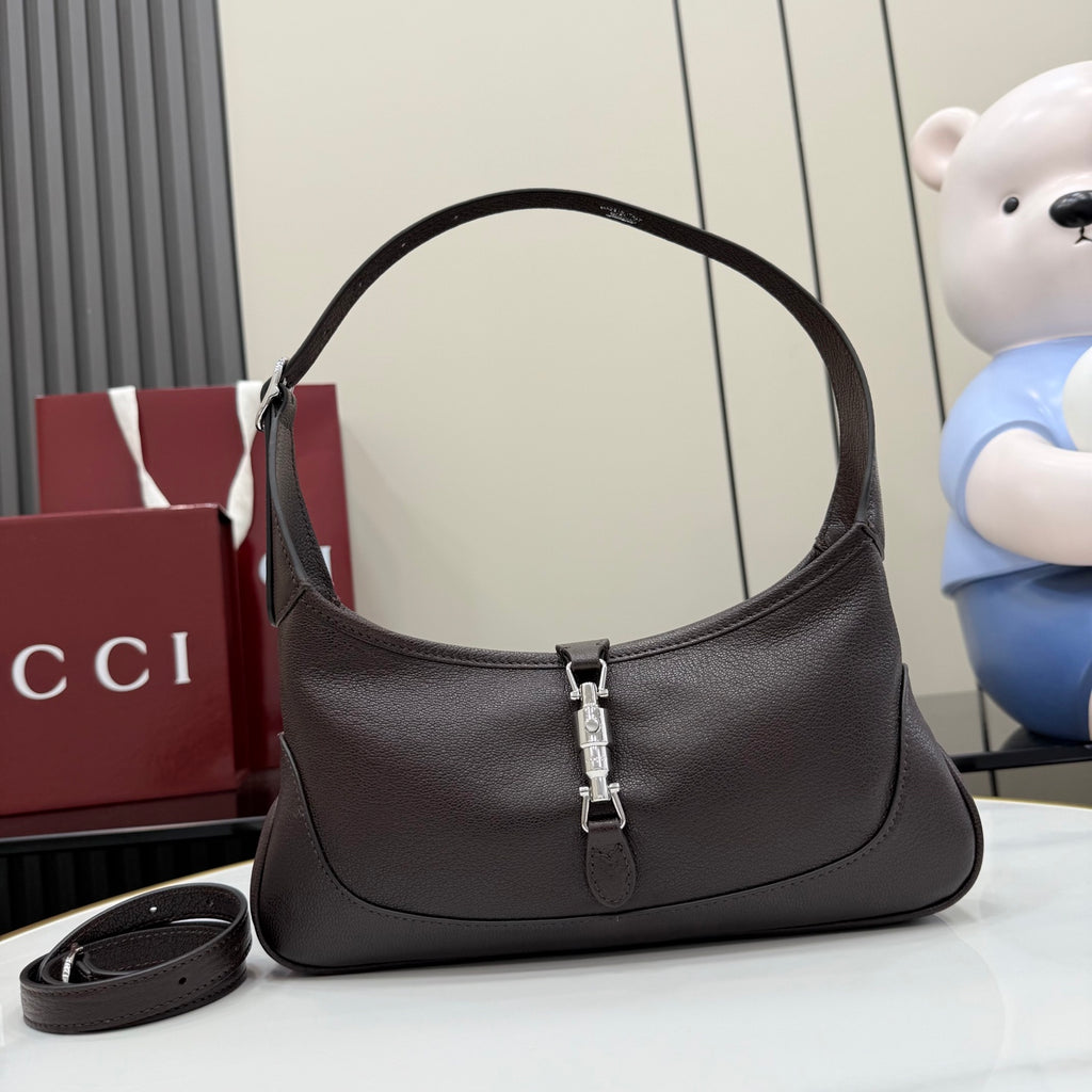 Dark leather hobo bag with curved handle and central silver-tone clasp hardware
