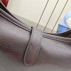 Dark leather hobo bag handle seam detail with stitched collar and curved edge