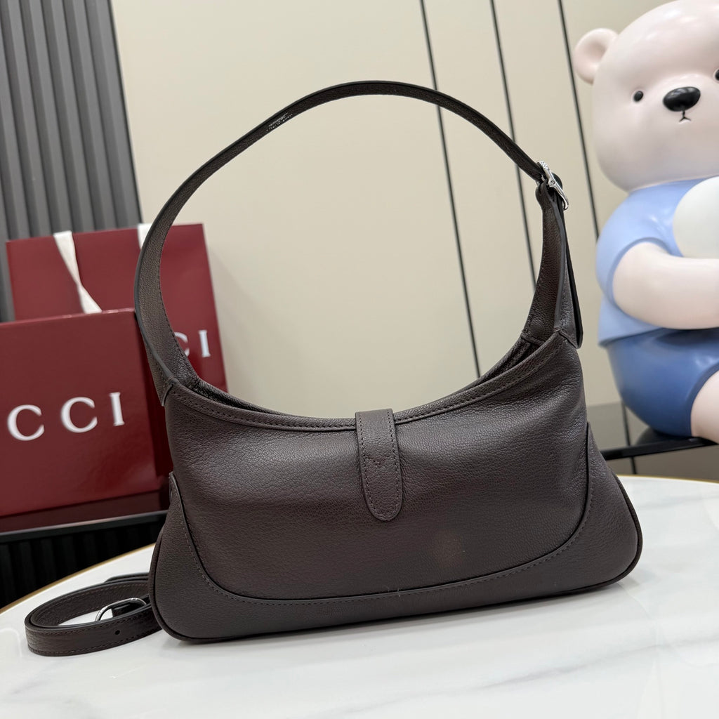 Dark leather hobo bag front view with rounded opening and curved top handle
