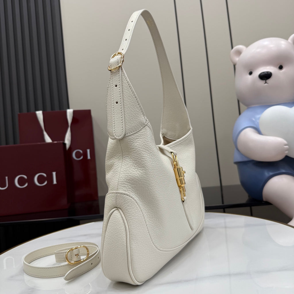 White leather shoulder bag with gold zipper pull and curved side