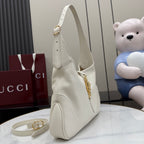 White leather shoulder bag with gold zipper pull and curved side