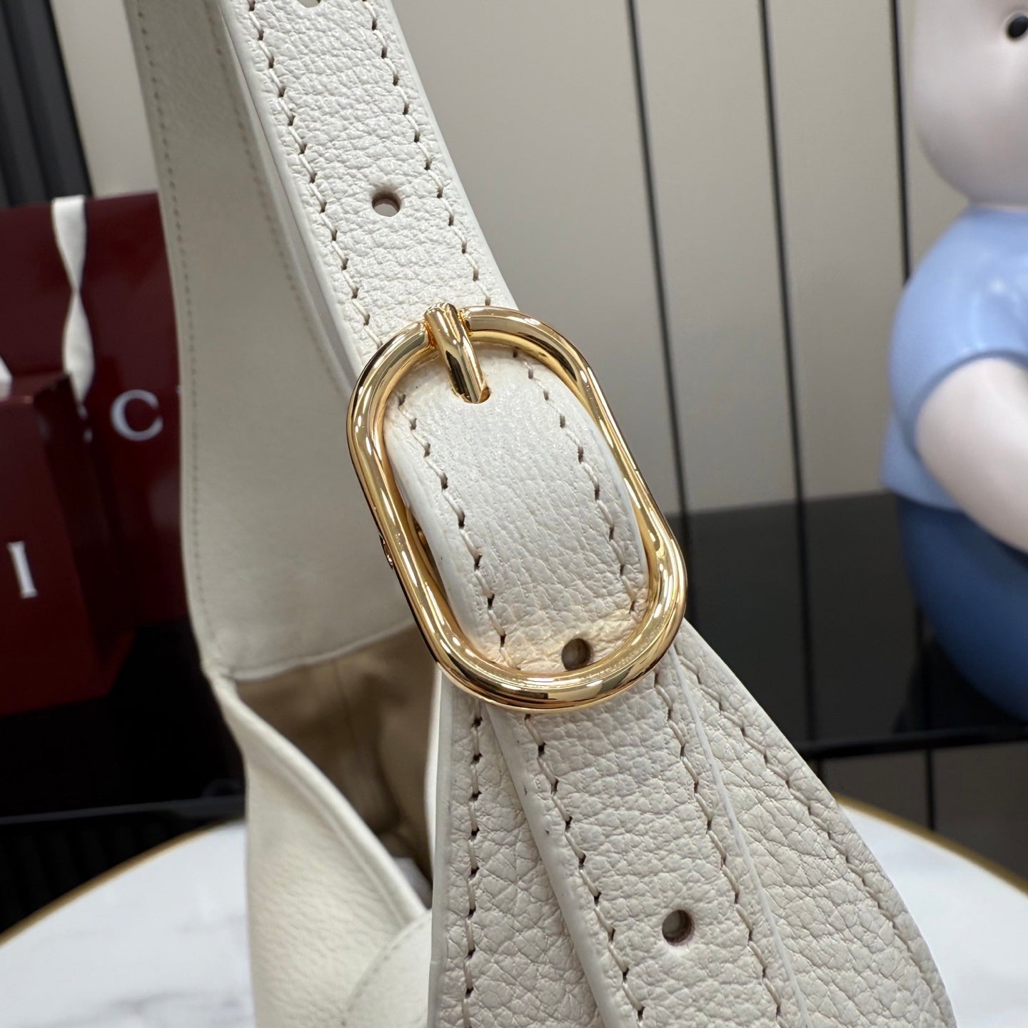White leather strap end with gold-tone oval buckle hardware